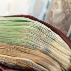 Stos banknotów w portfelu, w tle banknot 500 zł.