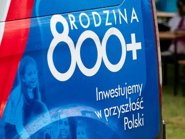 Niebieski baner z napisem "800+" i zdjęciami dzieci.