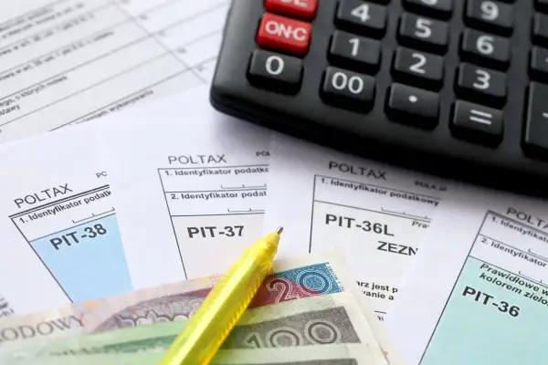 Kalkulator, polskie banknoty i formularze podatkowe PIT-38, PIT-37, PIT-36L, PIT-36.