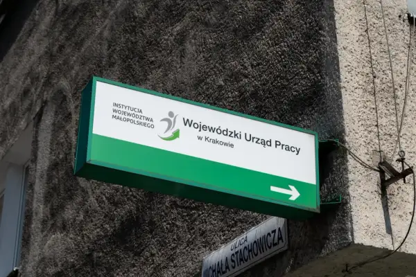 Tablica z napisem "Wojewódzki Urząd Pracy w Krakowie" i strzałką.